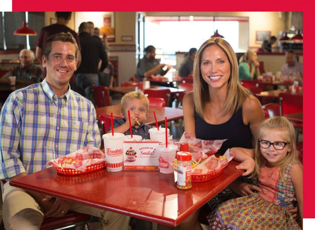 Happy family eating at a Freddy's Franchise